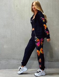 Close-up of vibrant butterfly print on black zip-up hoodie and matching joggers set