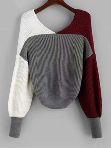 Detail view of tri-color colorblock knit sweater with V-neck and lantern sleeves