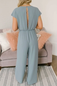 Detail of elegant open back design on a dusty blue wide-leg jumpsuit for women