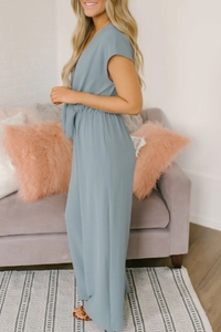 Detail of V-neck jumpsuit with waist bow tie and pleated elastic waistband in dusty blue