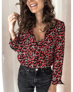 Détail du chemisier femme à col en V avec motifs de roses rouges et boutons dorés