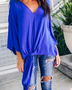 Detail view of royal blue chiffon blouse with V-neck and front tie knot design