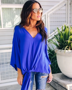 Detail of royal blue V-neck chiffon blouse featuring flutter sleeves and a knot waist design