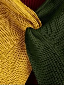 Macro detail of textured chunky knit sweater with twisted knot and color-block design