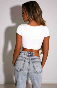 Rear view of white short sleeve crop top and light blue washed denim jeans on a model