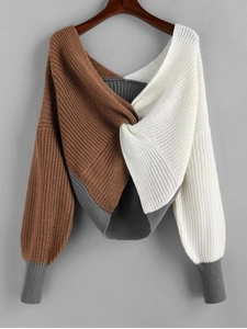 Close-up of color-block knit sweater featuring twist-knot design and V-neckline detail