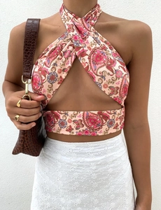 Detail of pink paisley halter wrap crop top paired with white embroidered skirt
