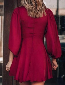 Détail du dos d'une robe rouge vin avec manches lanternes et coutures ajustées