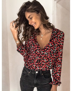 Détail de l'imprimé floral rouge sur chemisier à manches longues, col en V et boutons