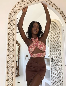 Detail of paisley print halter top and coffee brown ruched mini skirt with side slit