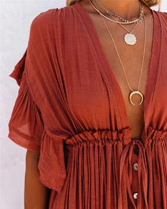 Detail of V-neck rust orange maxi dress with ruffle sleeves and drawstring waist detail