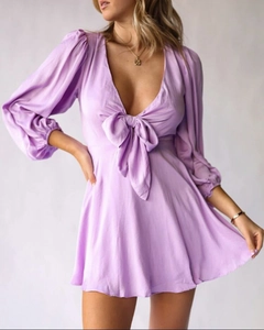 Détail du décolleté en V profond avec grand nœud papillon et manches bouffantes sur robe lilas