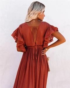 Detail view of the rust red maxi dress featuring ruffled sleeves and a tie back V-neckline