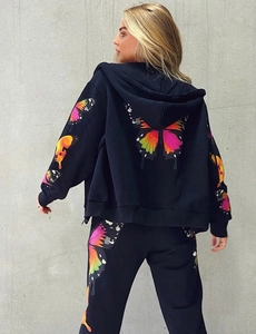 Detail of colorful butterfly prints on the back of a black hooded tracksuit set