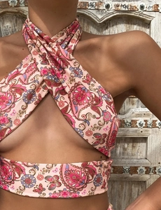 Detail of pink paisley print halter top with cross-neck cutout and floral patterns
