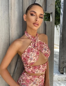 Detail of pink paisley print two-piece set with criss-cross halter crop top and matching pants