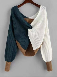 Detailed view of color-block knit sweater featuring a twist-front and textured fabric