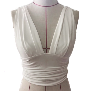 Detail view of white deep V-neck sleeveless top with pleated waist on mannequin