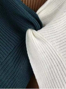 Close-up detail of multi-color ribbed knit fabric showing green, beige, and brown textures