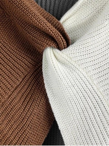 Close-up of color-block knit sweater featuring detailed brown and white twisted knot texture