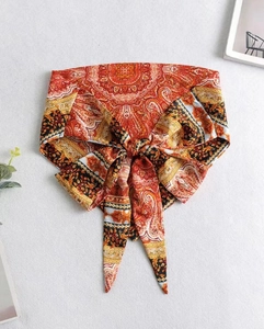 Detail of bohemian paisley print headband with pre-tied bow and vibrant ethnic patterns