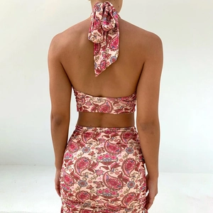 Detail view of pink paisley halter top with large back tie and ruched mini skirt