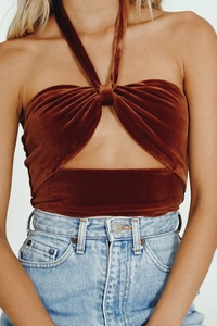Detail of rust brown velvet halter crop top with front twist and cutout design