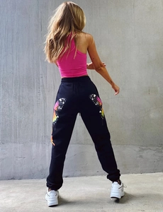 Detailed back view of black sweatpants featuring vibrant gradient butterfly prints