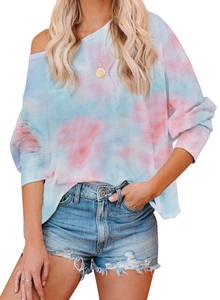 Détail du motif tie-dye rose et bleu sur le t-shirt ample à manches longues et épaule dénudée