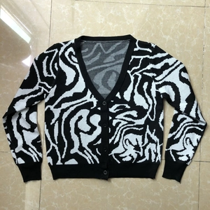 Detailed view of V-neck zebra pattern knit cardigan with black buttons on a flat surface