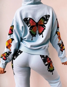 Detail view of colorful butterfly prints on back of light blue hoodie and jogger set