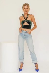 Detail of green velvet halter neck crop top with front twist and cutout detail
