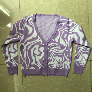 Detail of purple wavy knit pattern and button closure on V-neck women's cardigan