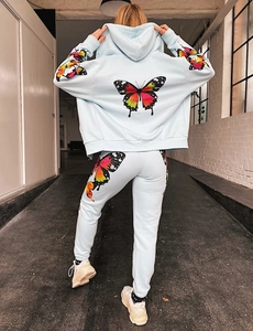 Detail of colorful butterfly prints on light blue hoodie and matching joggers set