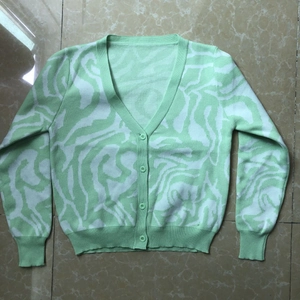 Detail view of marble texture knit cardigan with green buttons and ribbed cuffs