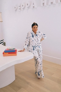 Detail of artistic hand-painted prints on a white linen shirt and wide-leg trousers set