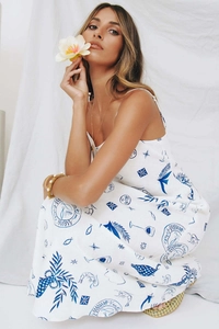 Detail of artistic blue hand-drawn prints and 'Vacation' stamp on white summer maxi dress