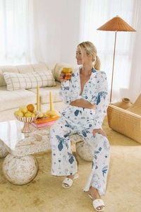Close-up of the blue hand-painted print on a linen white shirt and wide-leg trousers