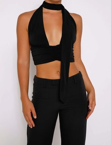 Détail d'un crop top licou noir avec décolleté en V profond et élégante écharpe assortie