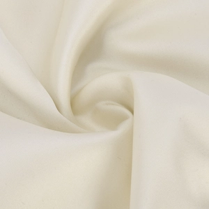 Gros plan sur un tissu en soie crème montrant une texture lisse et un drapé élégant