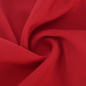 Vue macro d'un tissu en maille rouge vif montrant la texture douce et les fibres détaillées