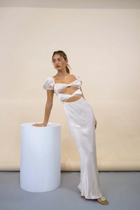 Détail de la taille évidée et manches bouffantes sur une robe longue en satin blanc