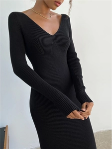 Close-up of the vertical ribbed texture and deep V-neckline on the black knit dress