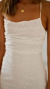 Detail of white daisy eyelet embroidery fabric and slim spaghetti straps on dress