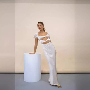 Robe longue en satin blanc avec manches bouffantes, découpe poitrine et lien à la taille