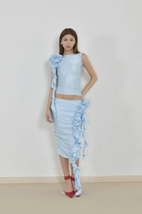 Détail d'accents floraux 3D et de franges sur un ensemble jupe en maille bleu clair
