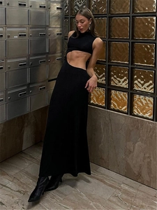 Détail d'une robe longue noire sans manches avec découpe latérale et coupe ajustée