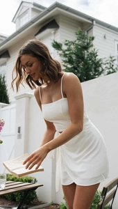 Detail of white linen crop top and wrap skirt with side tie in a summer holiday setting