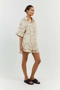 Detailaufnahme von beigem Kurzarmhemd und Shorts-Set mit abstrakten Linien