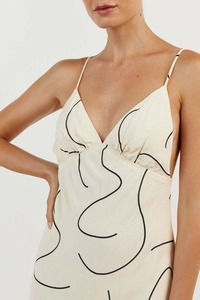 Detail of V-neckline and abstract black line pattern on cream summer midi dress